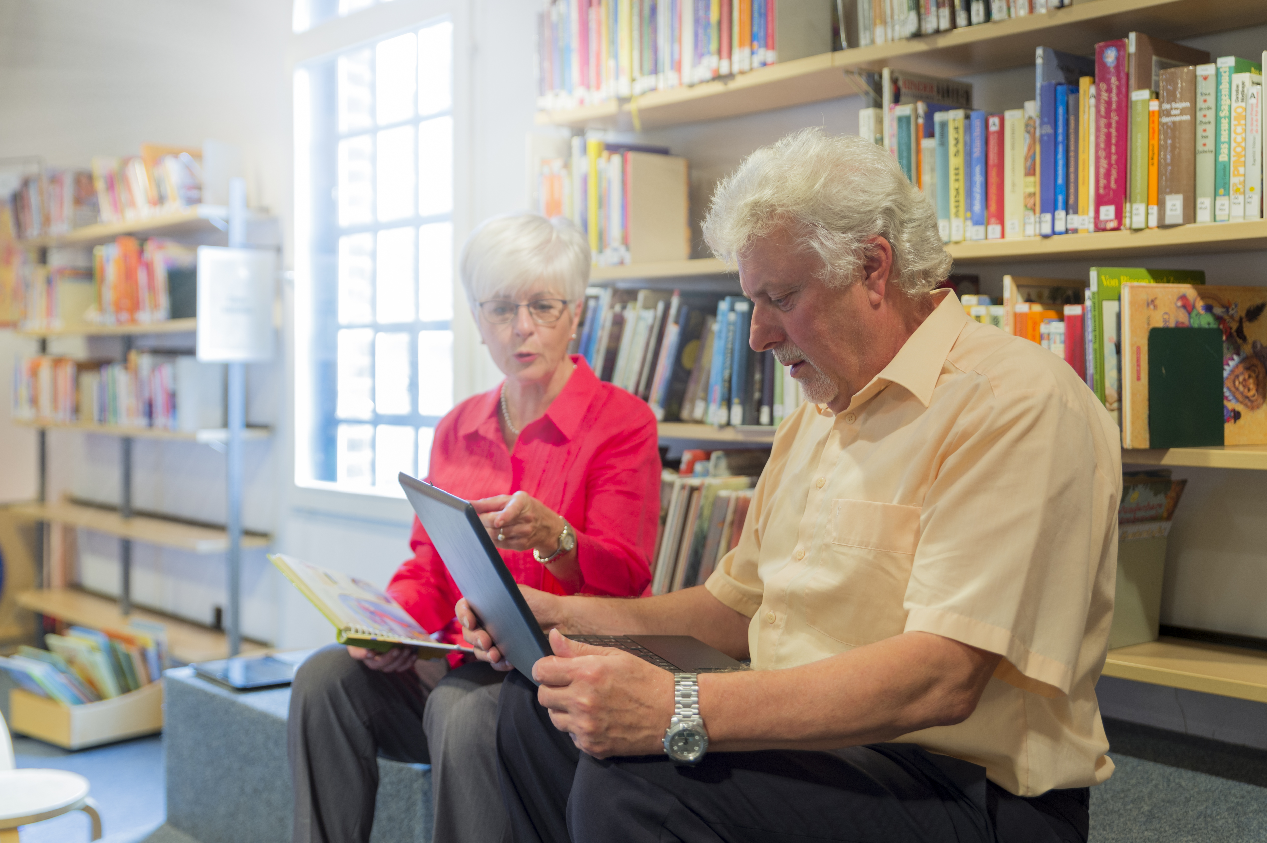Senior couple using a tablet together at the library