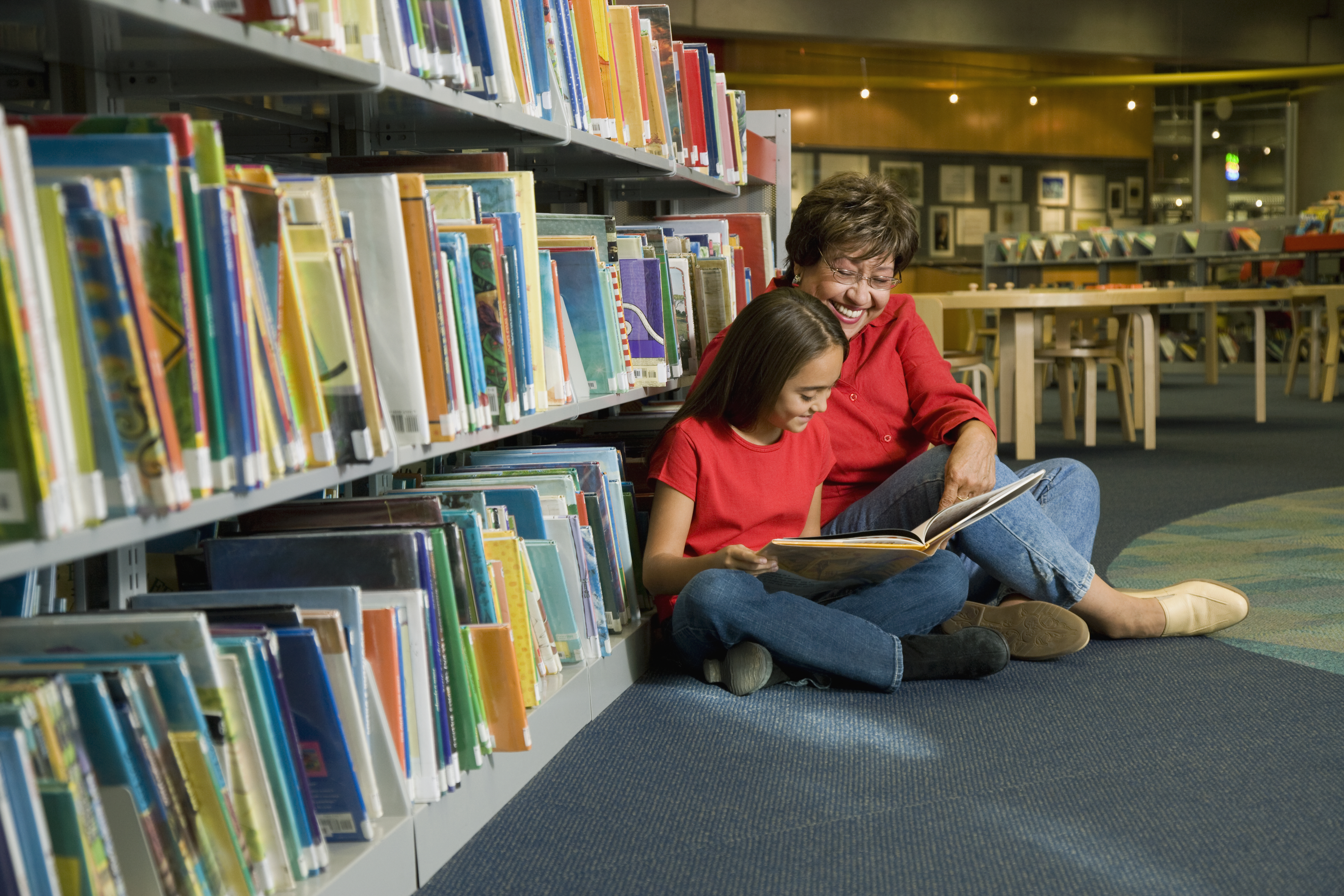 Adult and child reading together in the library